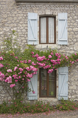 Fototapeta na wymiar Fenster, Fensterläden und Rosen an Bruchsteinhaus