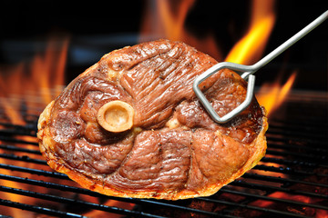 Grilled meat on the flaming grill ( lamb leg )
