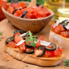 ciabatta with tomatoes, olives, parmesan on a board