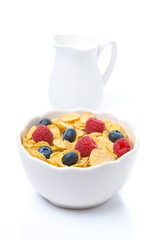 cornflakes with berries and jug of milk, isolated