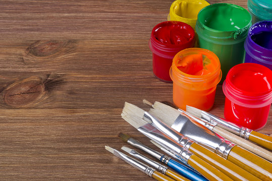 Many Brushes And Paint Pots On Wooden Table Background