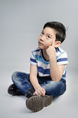 Portrait of little asian cute boy acting think about that .