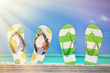 Two pairs of flip-flops against Atlantic. Exuma, Bahamas