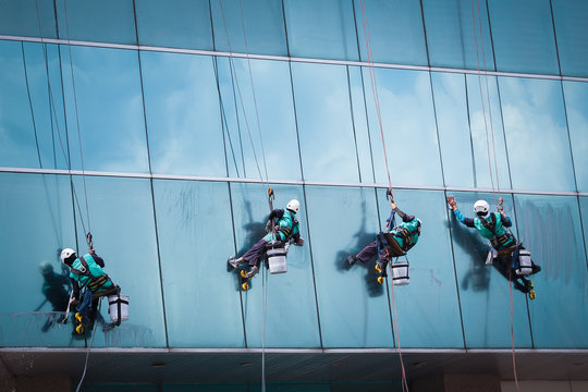 group of workers cleaning windows service on high rise building