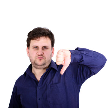 Portrait of disappointed young businessman showing thumb down