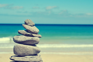 balanced stones in a white sand beach, with a cross-processed ef
