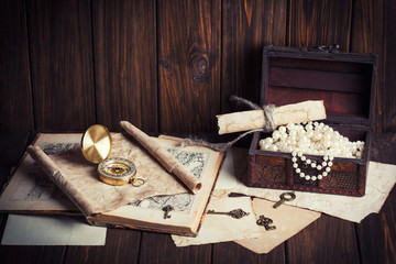 treasure chest, compass and old map on wooden table