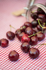Glass storage jar full of fresh cherries