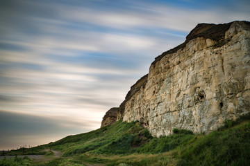 Long exposure landscape of motion blur sky over vibrant cliffs