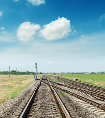 Fototapeta na wymiar crossing of two railroads and blue sky with clouds