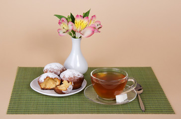 Tea, cupcakes and vase with the flowers