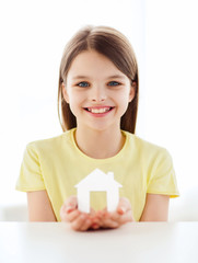 little girl holding white paper house