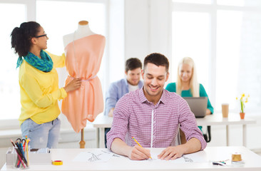 smiling fashion designers working in office