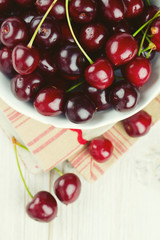cherries in a bowl on wooden background