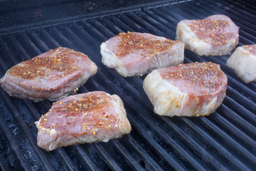 Beef steaks cooking on a grill