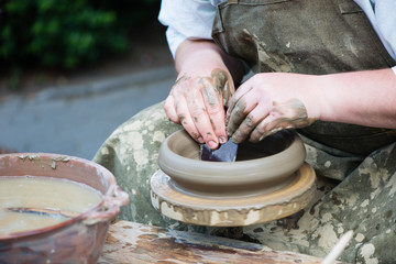 potter's hands working on ceramic jug