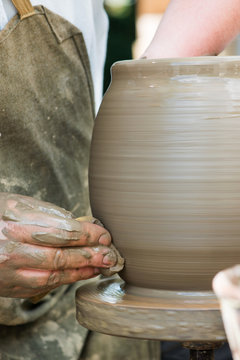 potter's hands working on ceramic jug