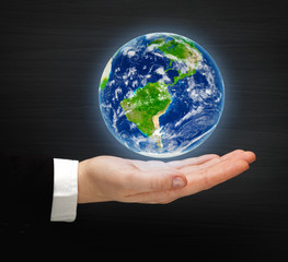 Planet Earth on a hand. Elements of this image furnished by NASA