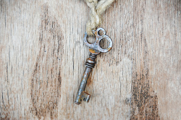 Vintage rusty key on old wooden background