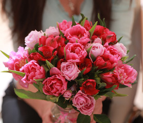bouquet of red flowers of different colors in the hands of the g