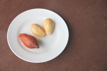 Fresh salacca edulis salak palm fruit of peeling in dish.