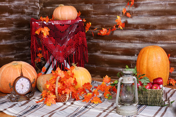 Orange big pumpkins, old lamp, clock and basket of fruits