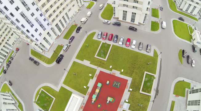 Parking with cars and playground in modern residential complex.