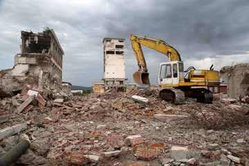 Bulldozer removes the debris from demolition of old buildings