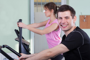 Fototapeta na wymiar Couple exercising at fitness gym