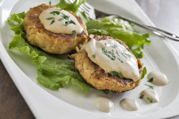 Crab cakes with a creamy mustard sauce and fresh parsley