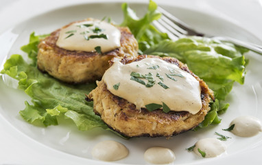 Crab cakes with a creamy mustard sauce and fresh parsley