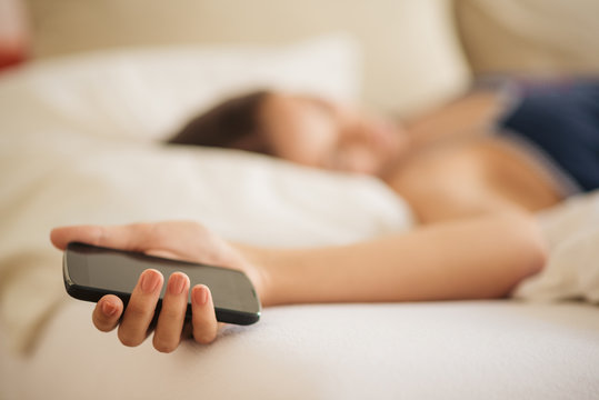 Lying In Bed And Holding Mobile Phone