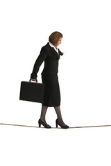 businesswoman balancing on a tightrope isolated on white