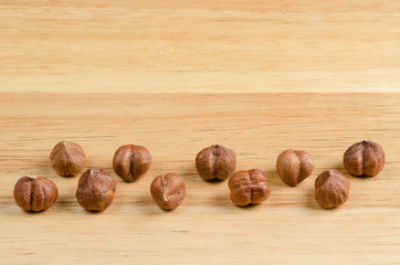 toasted hazelnuts without shells, on wood, background