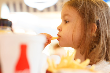 Little girl eating fast food french fries