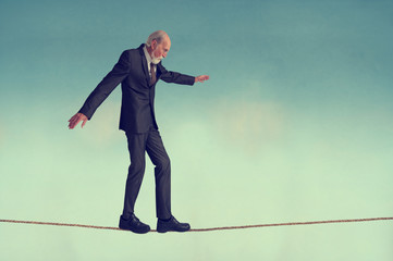 senior man walking a tightrope