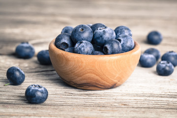 bowl of blueberries on wooden background