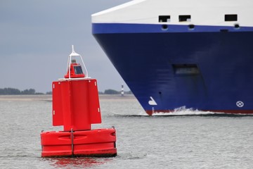 rote Fahrwassertonne an einem Schifffahrtsweg