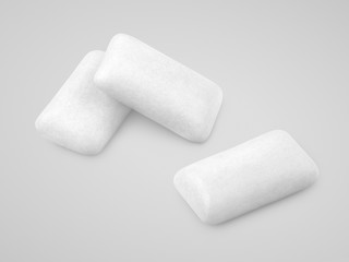 Three pieces of white chewing gums on gray with clipping path