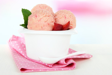Tasty ice cream scoops in bowl, on table
