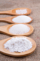 Fototapeta na wymiar Various type of white sugar in wooden spoon on gunny sack
