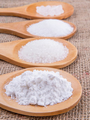 Fototapeta na wymiar Various type of white sugar in wooden spoon on gunny sack