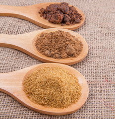 Muscovado sugar, brown sugar and coconut sugar in wooden spoon