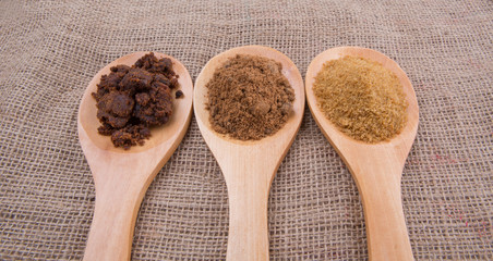 Muscovado sugar, brown sugar and coconut sugar in wooden spoon