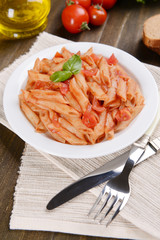 Pasta with tomato sauce on plate on table close-up