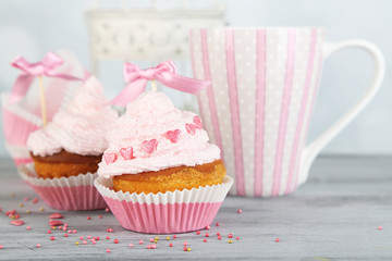 Tasty cup cakes with cream on grey wooden table