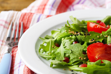 Green salad made with  arugula, tomatoes and sesame