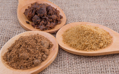 Muscovado sugar, brown sugar and coconut sugar in wooden spoon