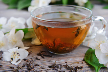 Cup of tea with jasmine on table close-up