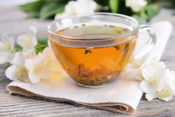 Cup of tea with jasmine on table close-up